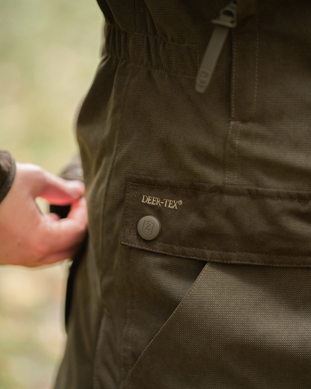 Tarmac Green coloured Deerhunter Lady Eagle Winter Jacket on blurry background #colour_tarmac-green