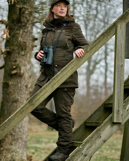 Tarmac Green coloured Deerhunter Lady Eagle Winter Trousers on forest background #colour_tarmac-green