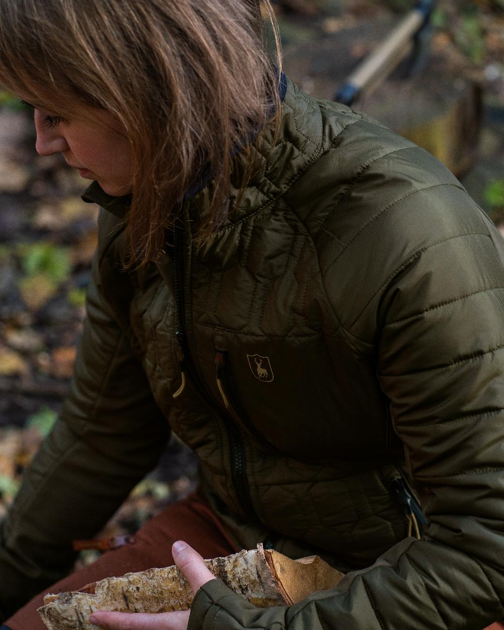 Forest Green coloured Deerhunter Lady Mossdale Quilted Jacket on forest background #colour_forest-green