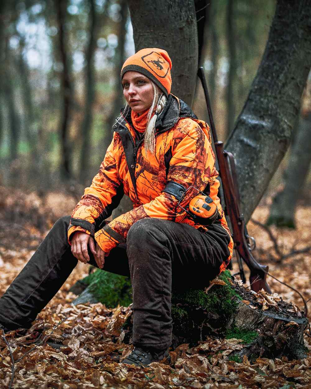 Orange coloured Deerhunter Logo Neck Tube on forest background #colour_orange
