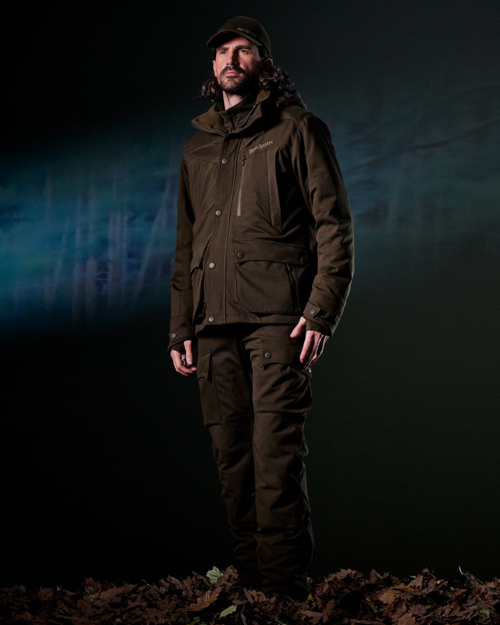 Art Green coloured Deerhunter Mens Muflon Pro Trousers on forest background #colour_art-green