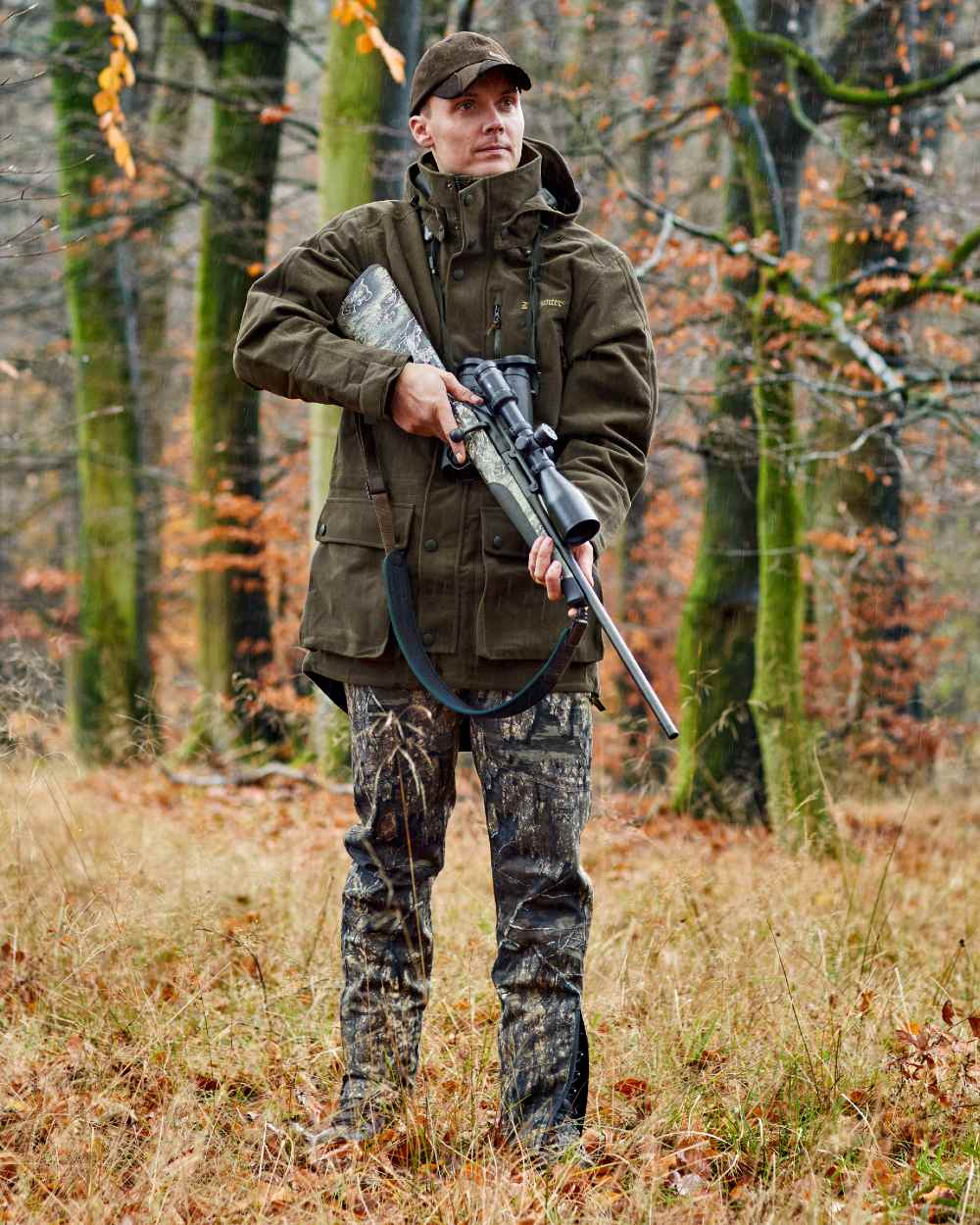 Peat Coloured Deerhunter Pro Gamekeeper Boot Trousers on forest background #colour_peat