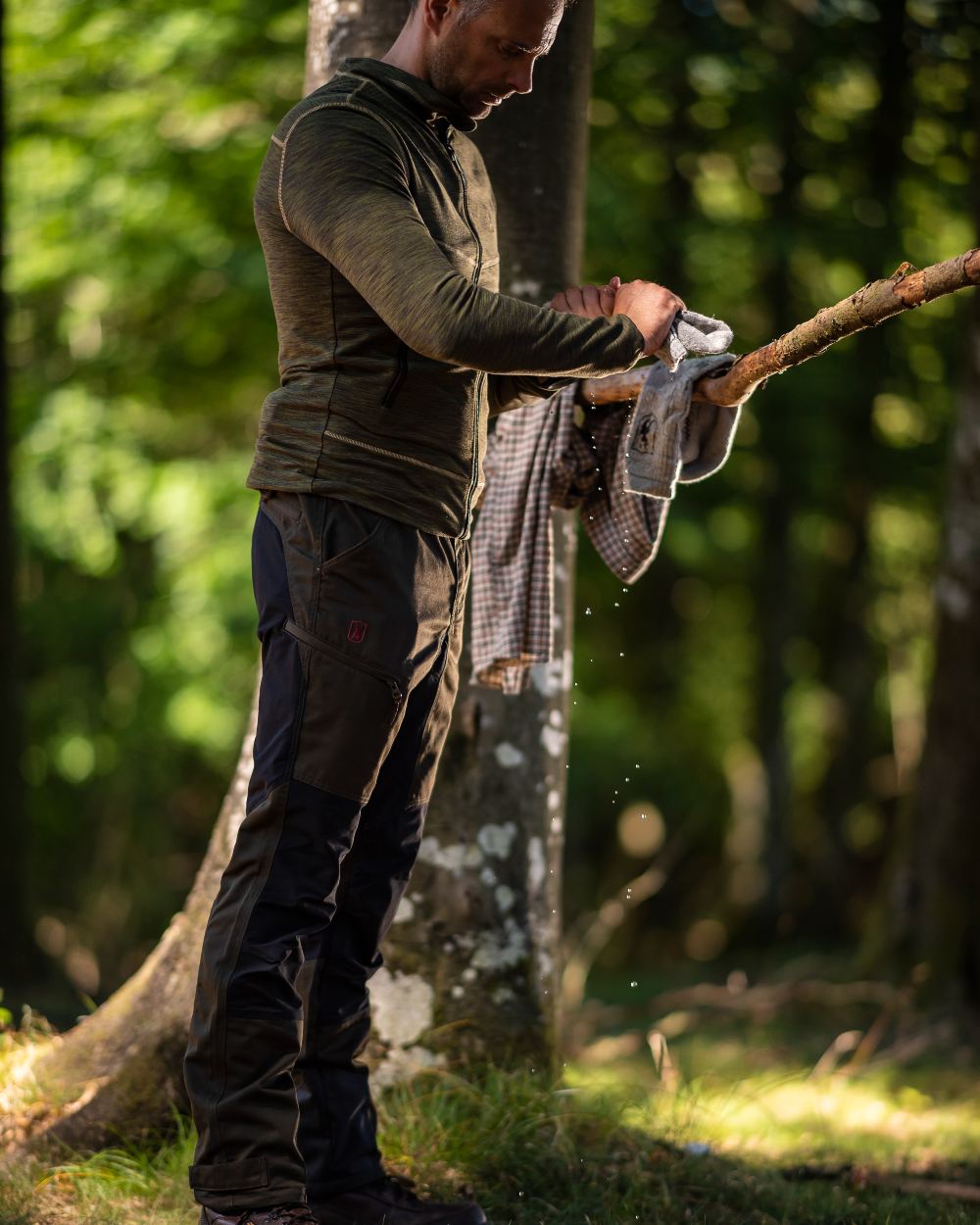 Adventure Green Coloured Deerhunter Rogaland Contrast Stretch Trousers on forest background #colour_adventure-green