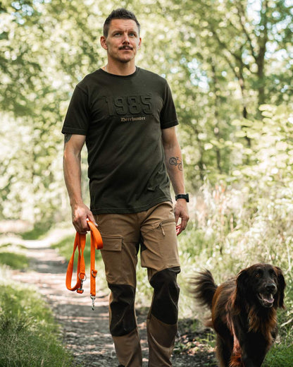 Butternut Fallen Leaf Black coloured Deerhunter Sarek Full Stretch Trousers on forest background #colour_butternut-fallen-leaf