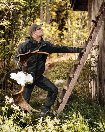 Black Ink coloured Deerhunter Strike Trousers on forest background #colour_black-ink