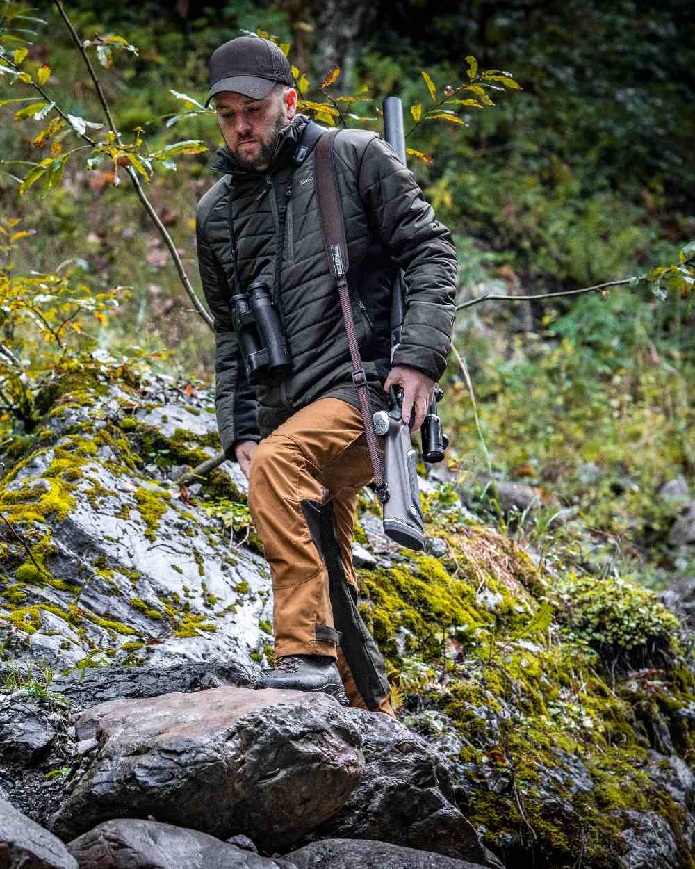 Bronze coloured Deerhunter Strike Trousers on forest background #colour_bronze