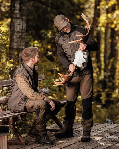 Fallen Leaf coloured Deerhunter Strike Trousers on forest background #colour_fallen-leaf