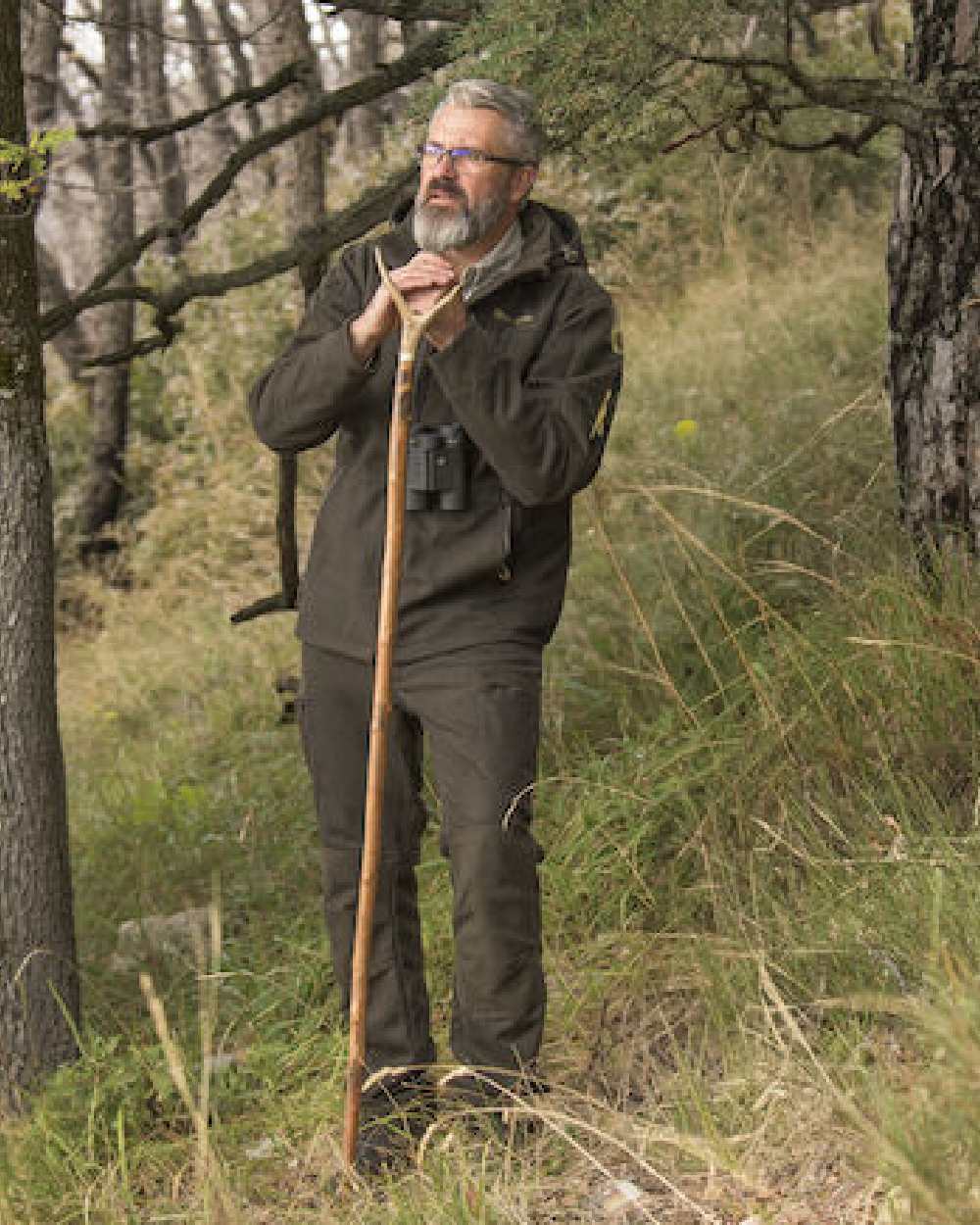 Loden Wood coloured Deerhunter Tatra Trousers on forest background #colour_loden-wood