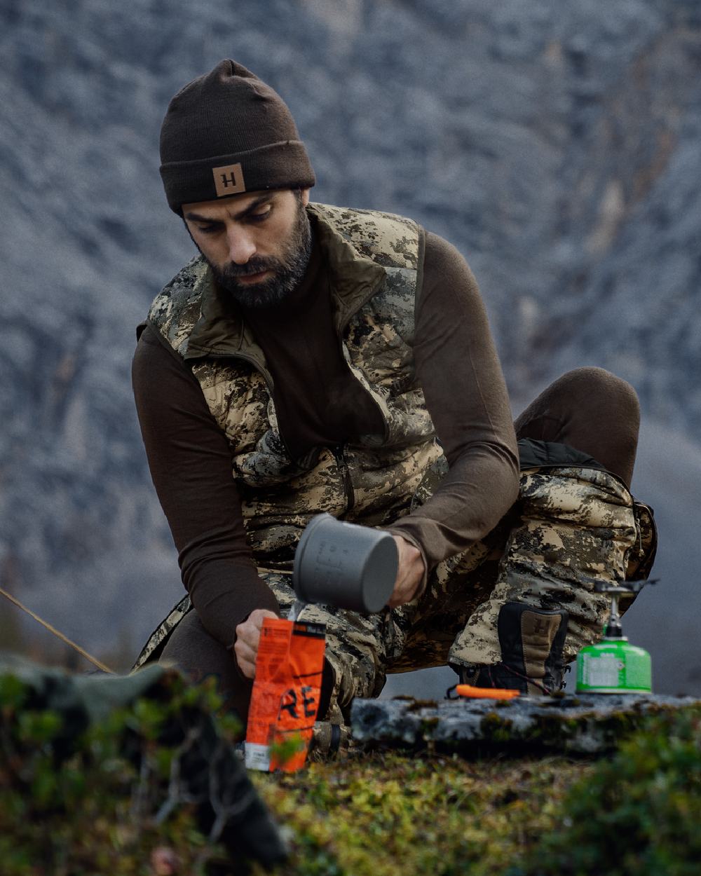 Shadow Brown Coloured Harkila All Season Half Zip Base Layer on mountain background #colour_shadow-brown