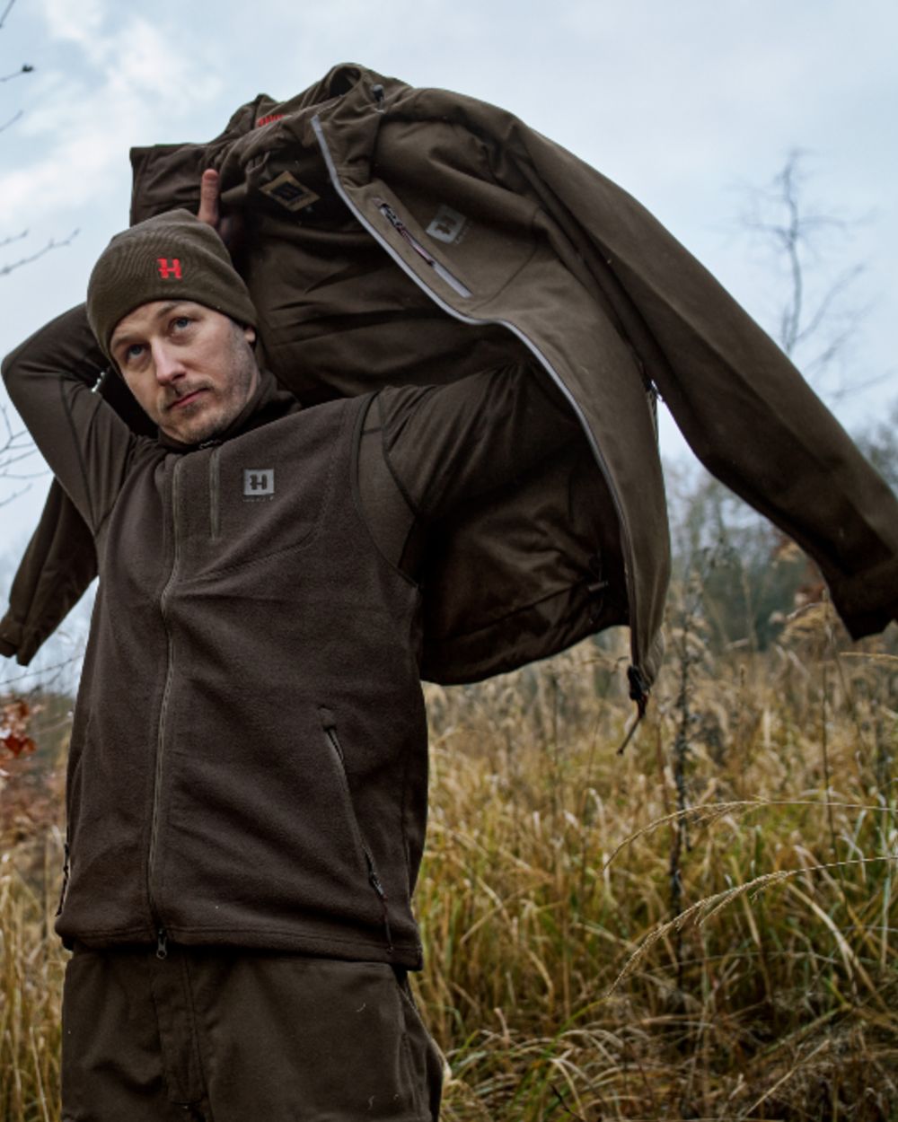 Shadow Brown Coloured Harkila Aspire Fleece Waistcoat on outdoor background #colour_shadow-brown