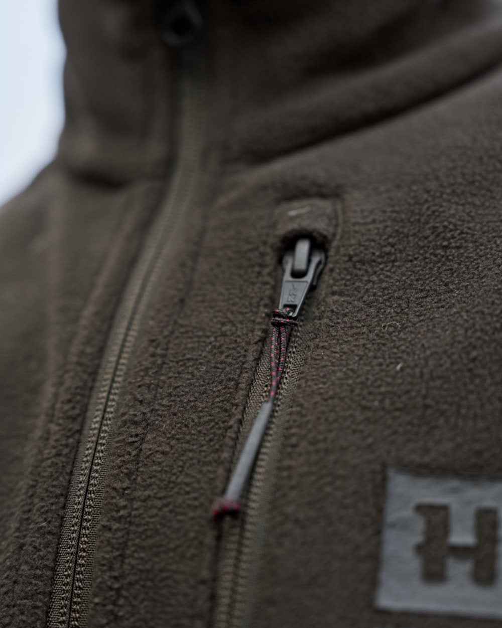 Shadow Brown Coloured Harkila Aspire Fleece Waistcoat on outdoor background #colour_shadow-brown