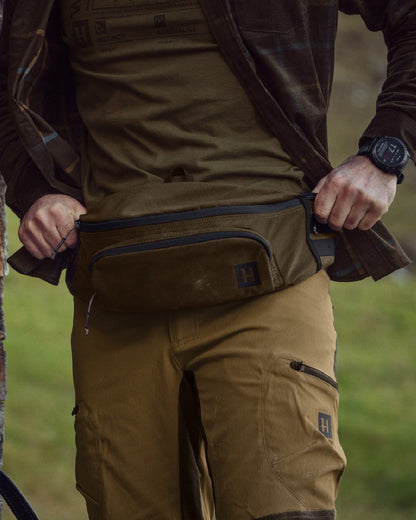 Willow Green Coloured Harkila Deer Stalker Waist Pack on outdoor background #colour_willow-green
