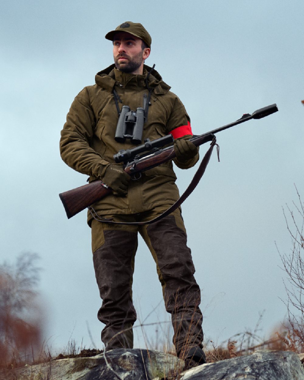 Willow Green Shadow Brown Coloured Harkila Driven Hunt HWS Leather Trousers on forest background #colour_willow-green-shadow-brown