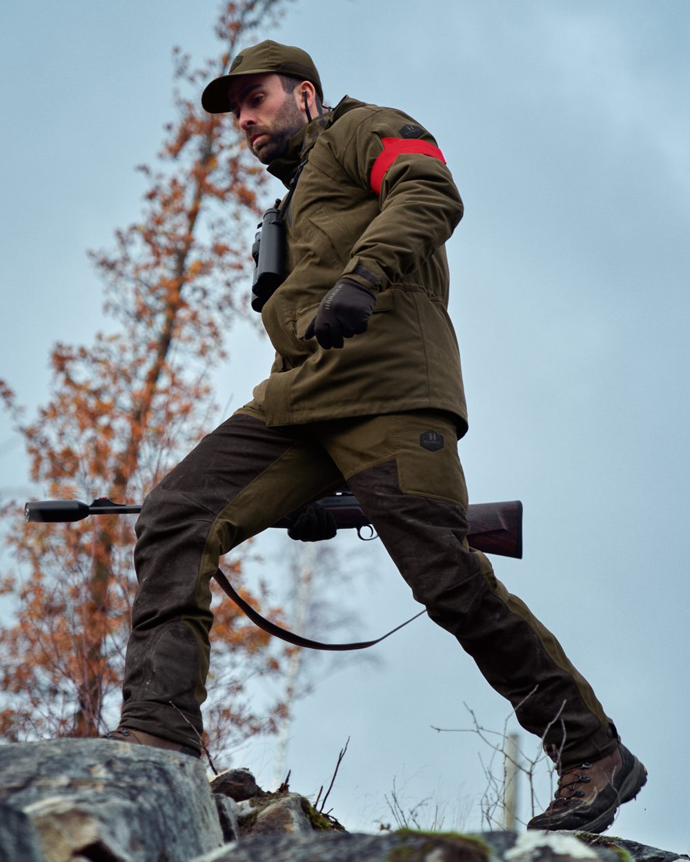 Willow Green Shadow Brown Coloured Harkila Driven Hunt HWS Leather Trousers on forest background #colour_willow-green-shadow-brown