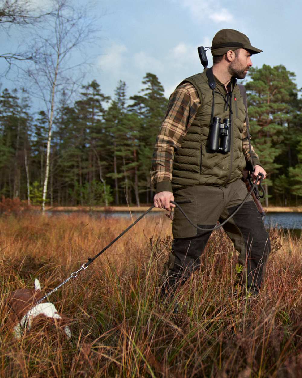 Willow Green Shadow Brown Coloured Harkila Driven Hunt HWS Leather Trousers on forest background #colour_willow-green-shadow-brown