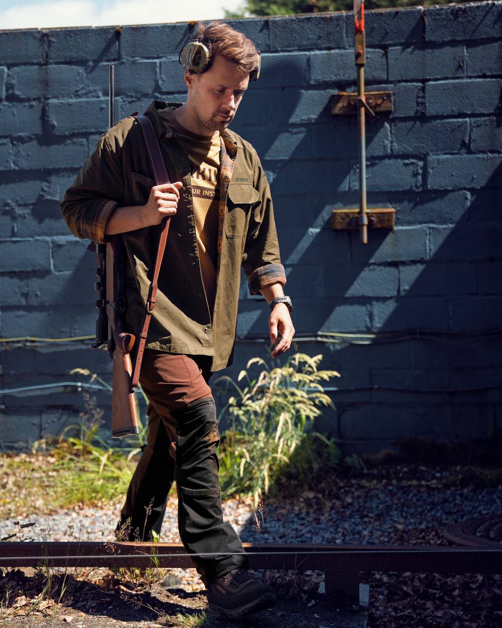 Dark Warm Olive Burgundy Coloured Harkila Eirik Reversible Shirt Jacket on countryside background #colour_dark-warm-olive-burgundy