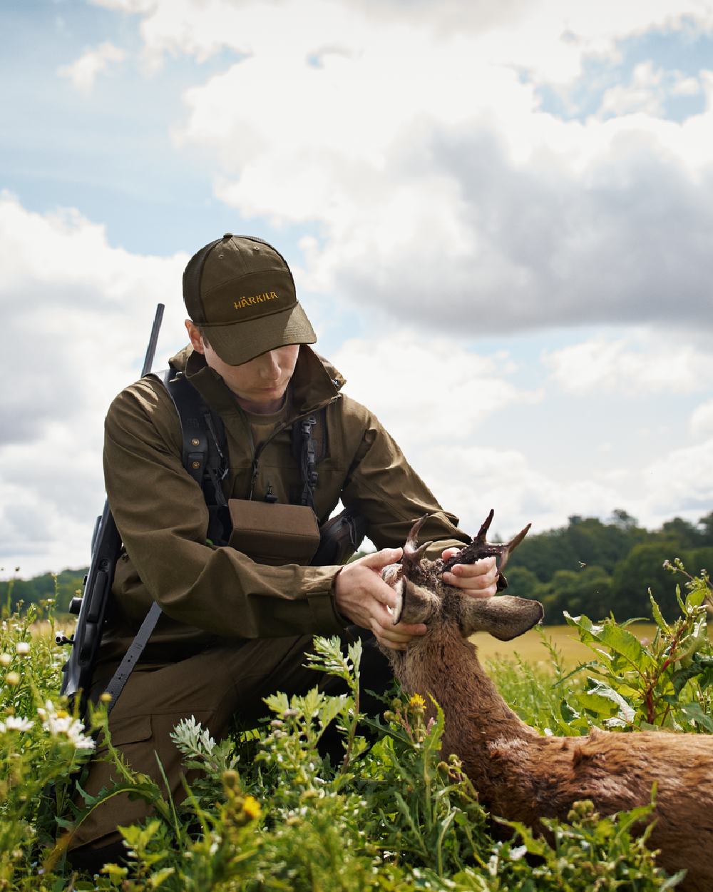 Hunting Green Coloured Harkila Finnmark HWS Jacket on forest background #colour_hunting-green