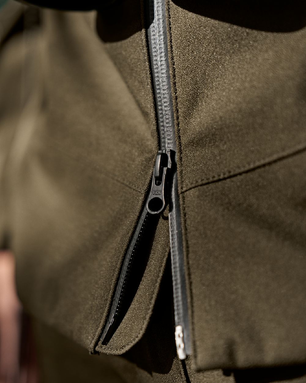Hunting Green Coloured Harkila Finnmark HWS Jacket on blurry background #colour_hunting-green