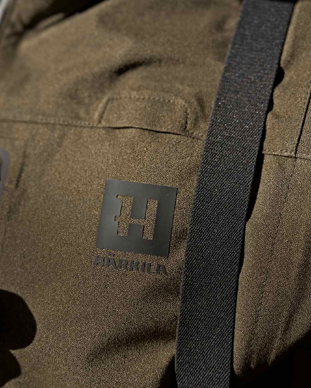 Hunting Green Coloured Harkila Finnmark HWS Jacket on blurry background #colour_hunting-green