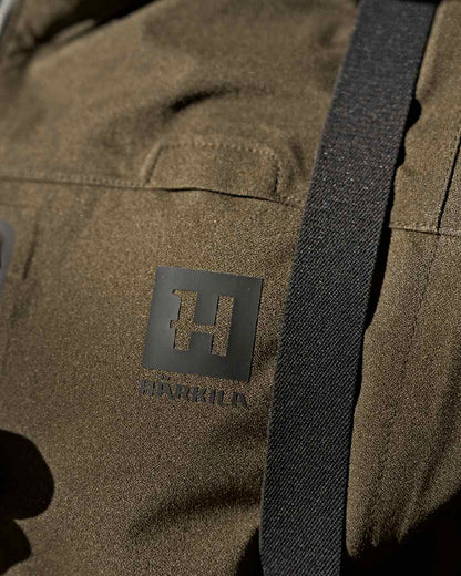 Hunting Green Coloured Harkila Finnmark HWS Jacket on blurry background #colour_hunting-green