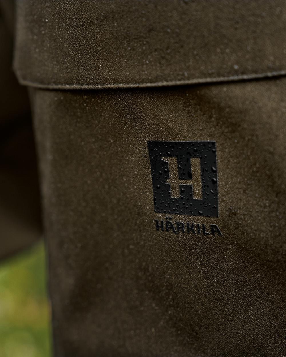 Hunting Green Coloured Harkila Finnmark HWS Trousers on blurry background #colour_hunting-green