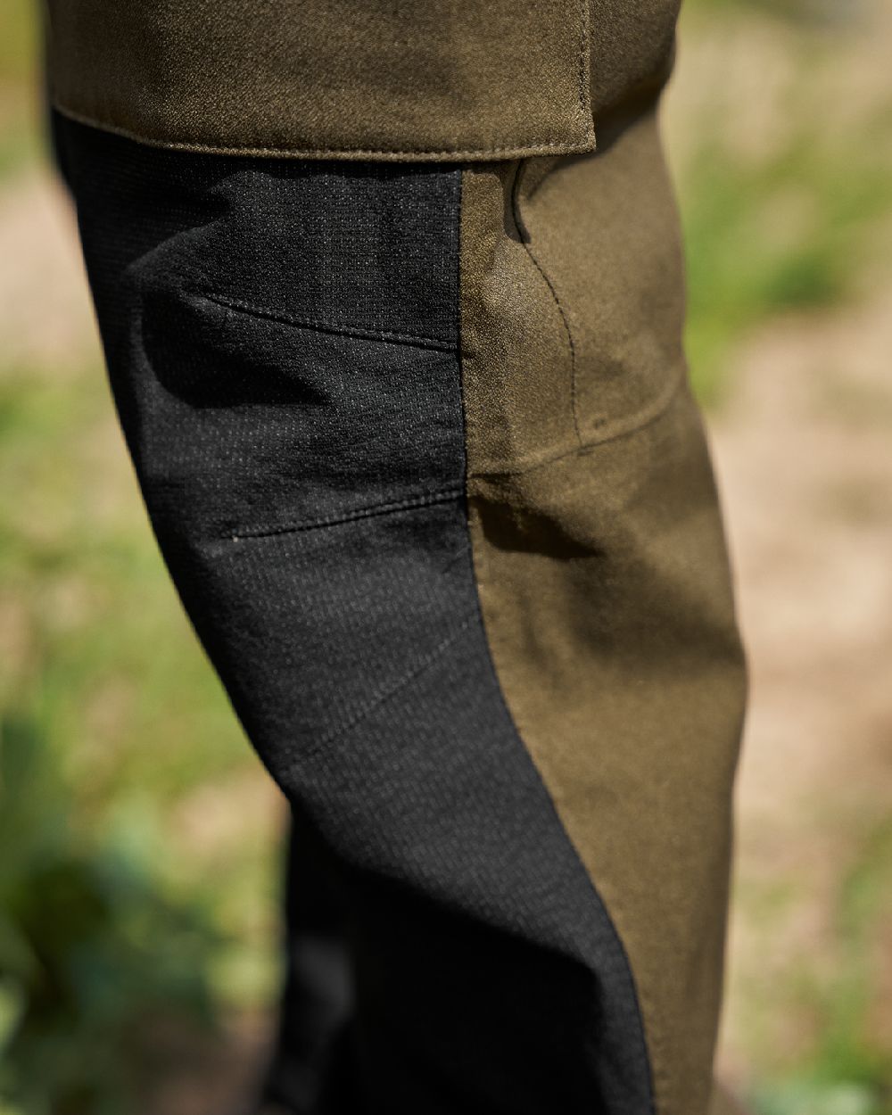 Hunting Green Coloured Harkila Finnmark HWS Trousers on blurry background #colour_hunting-green
