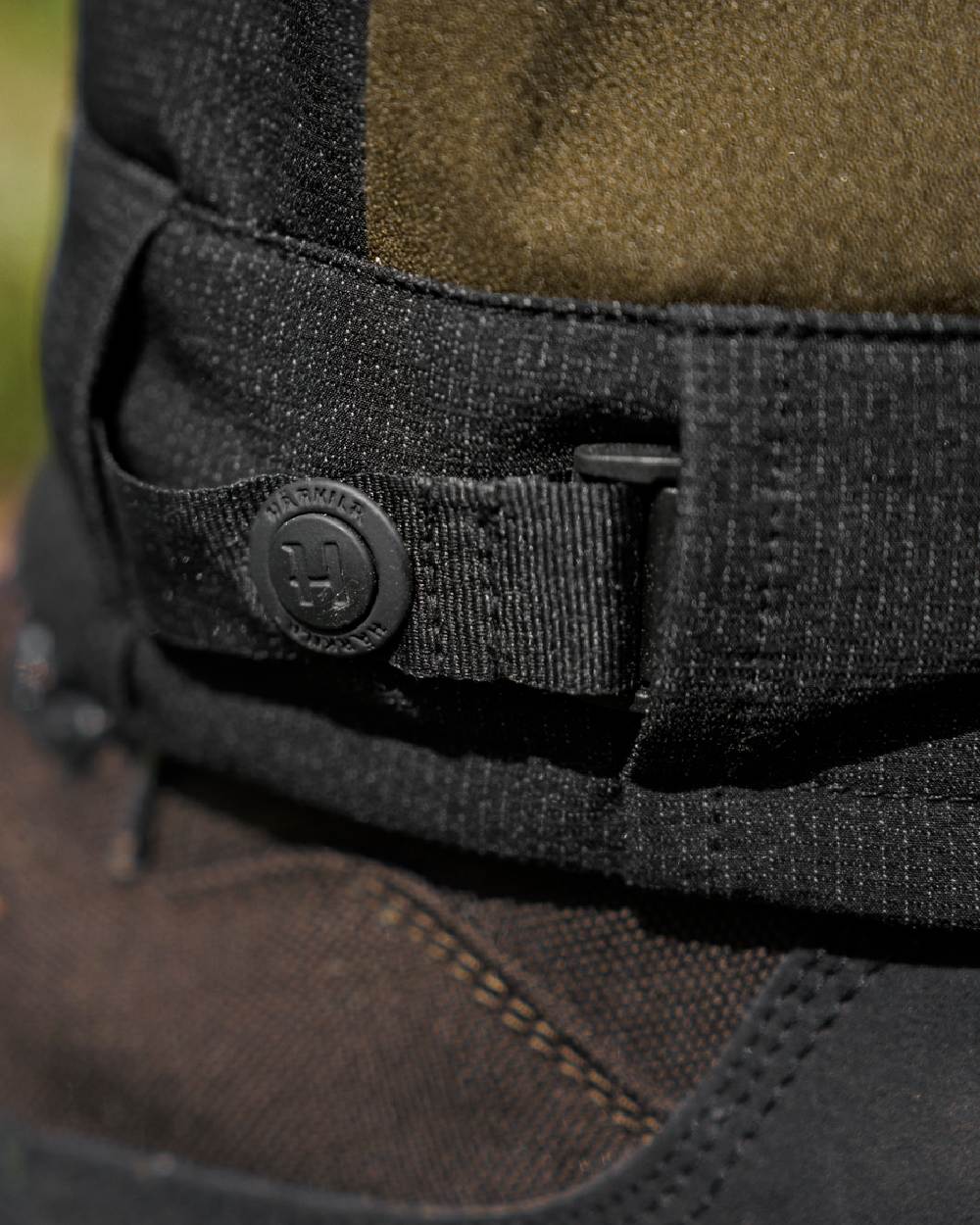 Hunting Green Coloured Harkila Finnmark HWS Trousers on blurry background #colour_hunting-green