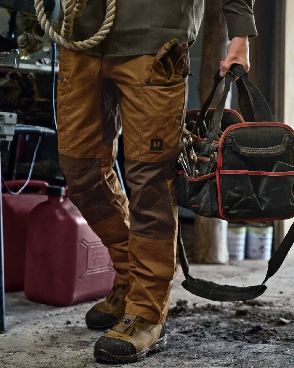 Rustique Clay Brown Coloured Harkila Fjell Trousers on factory background #colour_rustique-clay-brown
