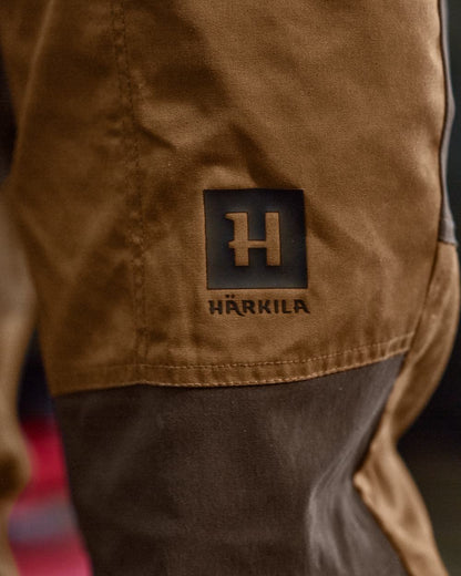 Rustique Clay Brown Coloured Harkila Fjell Trousers on factory background #colour_rustique-clay-brown