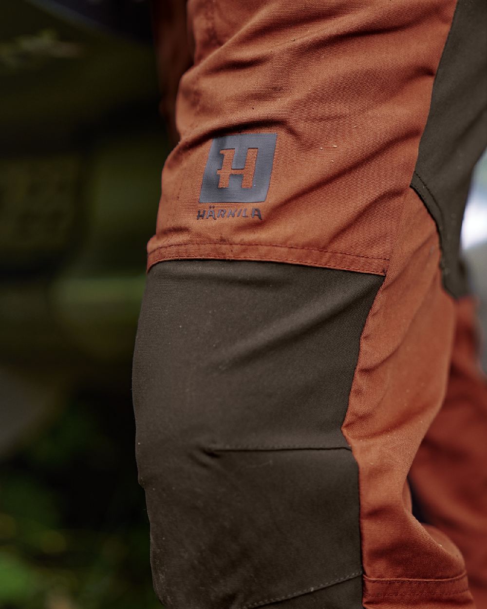 Shadow Brown Arabian Spice Coloured Harkila Fjell Trousers on blurry background #colour_shadow-brown-arabian-spice