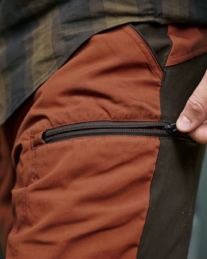 Shadow Brown Arabian Spice Coloured Harkila Fjell Trousers on blurry background #colour_shadow-brown-arabian-spice