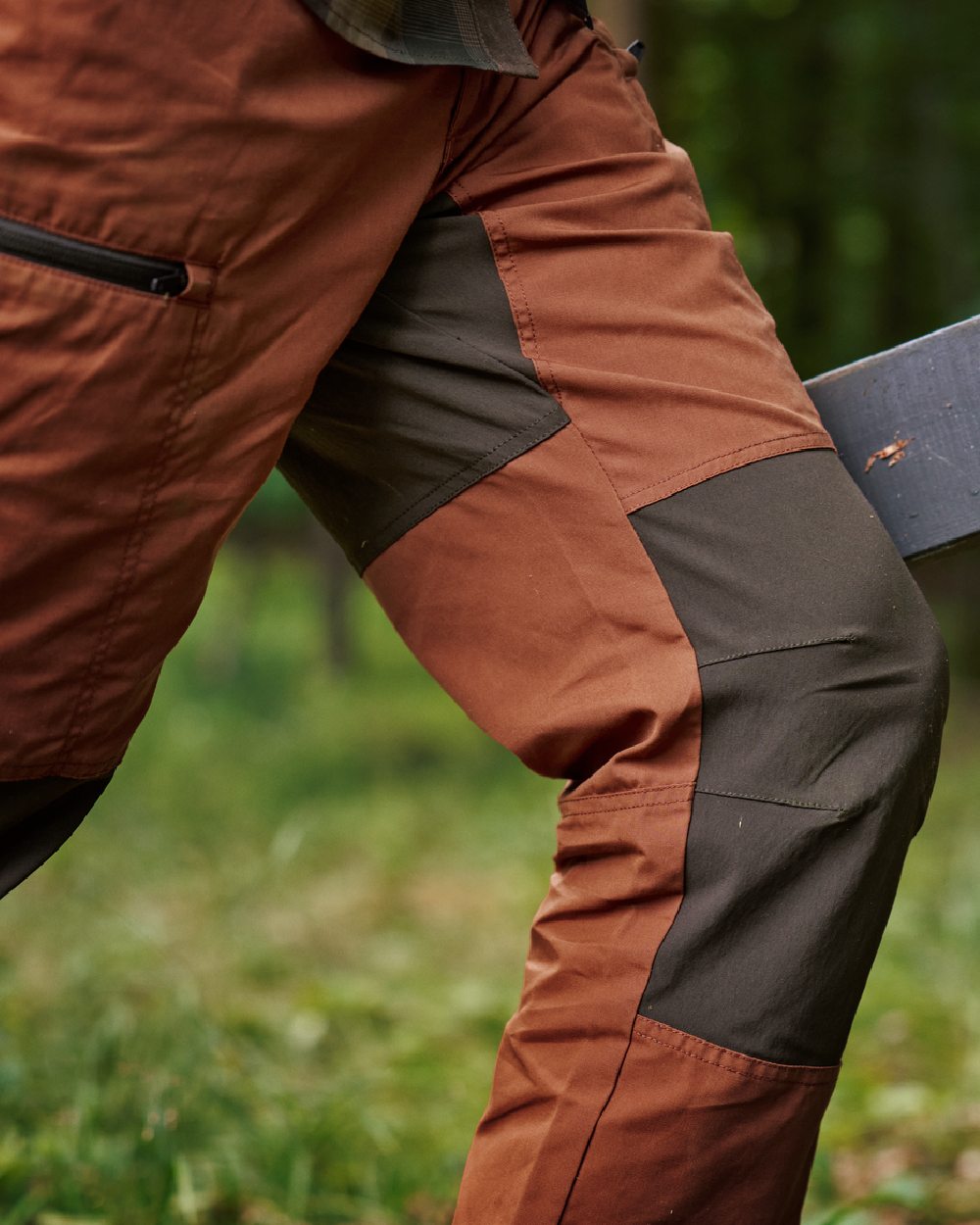 Shadow Brown Arabian Spice Coloured Harkila Fjell Trousers on blurry background #colour_shadow-brown-arabian-spice