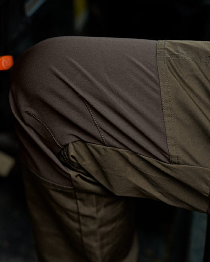 Willow Green Shadow Brown Coloured Harkila Fjell Trousers on blurry background #colour_willow-green-shadow-brown