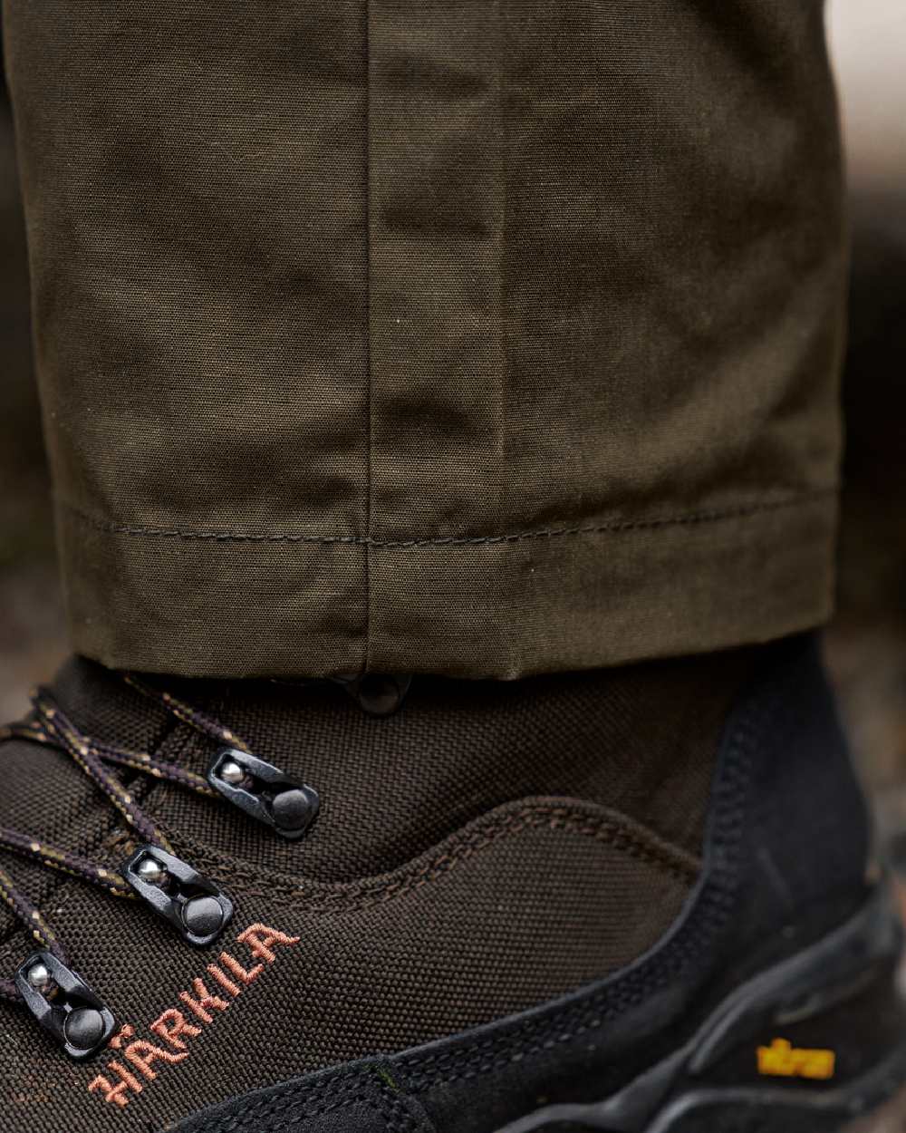 Willow Green Shadow Brown Coloured Harkila Fjell Trousers on blurry background #colour_willow-green-shadow-brown