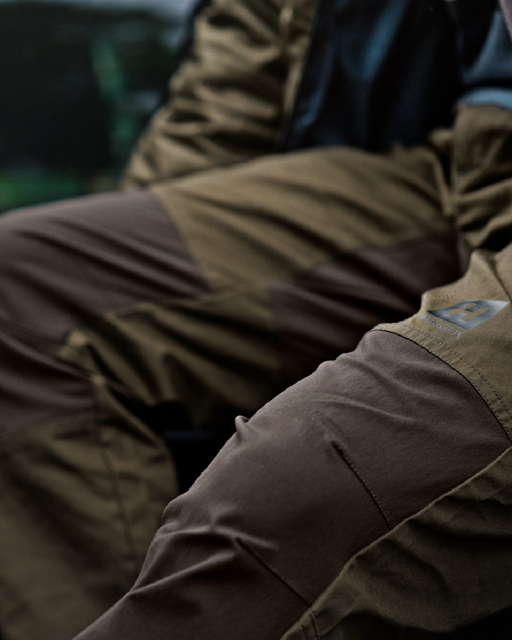 Willow Green Shadow Brown Coloured Harkila Fjell Trousers on blurry background #colour_willow-green-shadow-brown