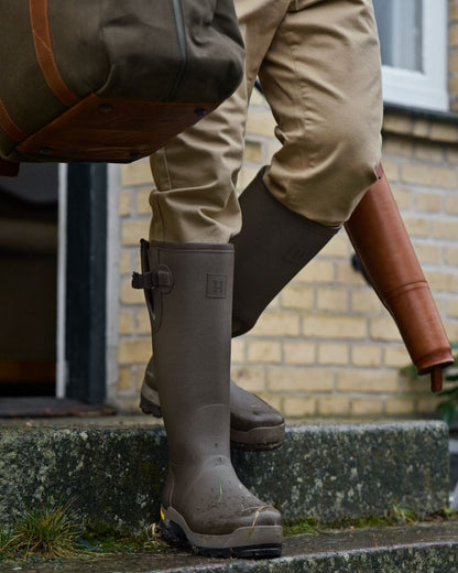 Dark Willow Green Coloured Harkila Forester Gusset Rubber Boots on outdoor background #colour_dark-willow-green