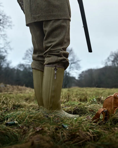 Dark Olive Coloured Harkila Forester Zip Rubber Boot on outdoor background #colour_dark-olive