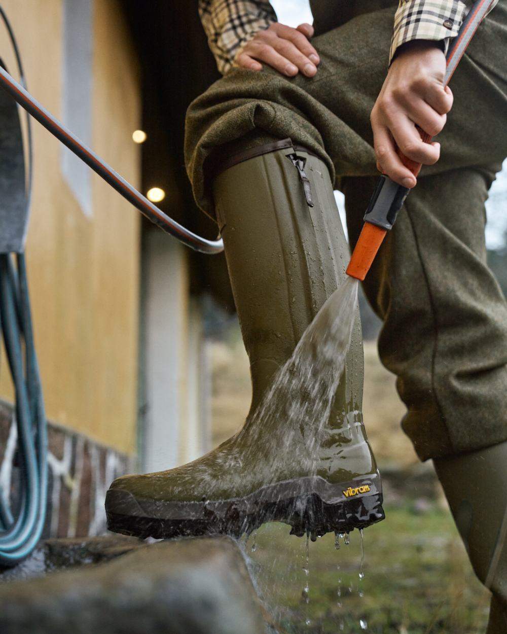 Dark Olive Coloured Harkila Forester Zip Rubber Boot on outdoor background #colour_dark-olive