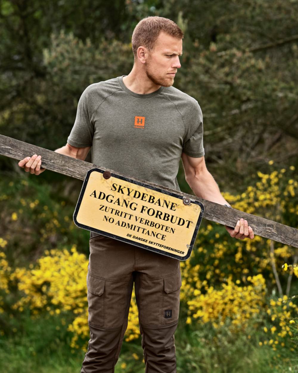 Green Melange coloured Harkila Instinct Short Sleeve T-Shirt on forest background #colour_green-melange