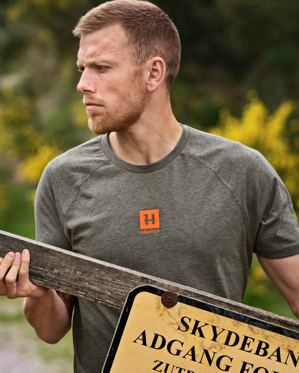 Green Melange coloured Harkila Instinct Short Sleeve T-Shirt on forest background #colour_green-melange