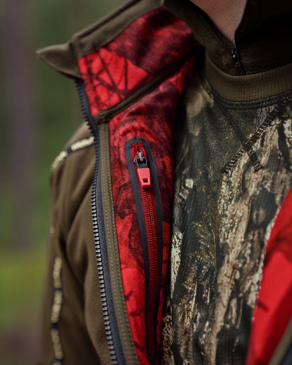 Hunting Green Mossy Oak Break-up Country Coloured Harkila Kamko Camo Reversible WSP Jacket on blurry background #colour_hunting-green-mossy-oak-break-up-country