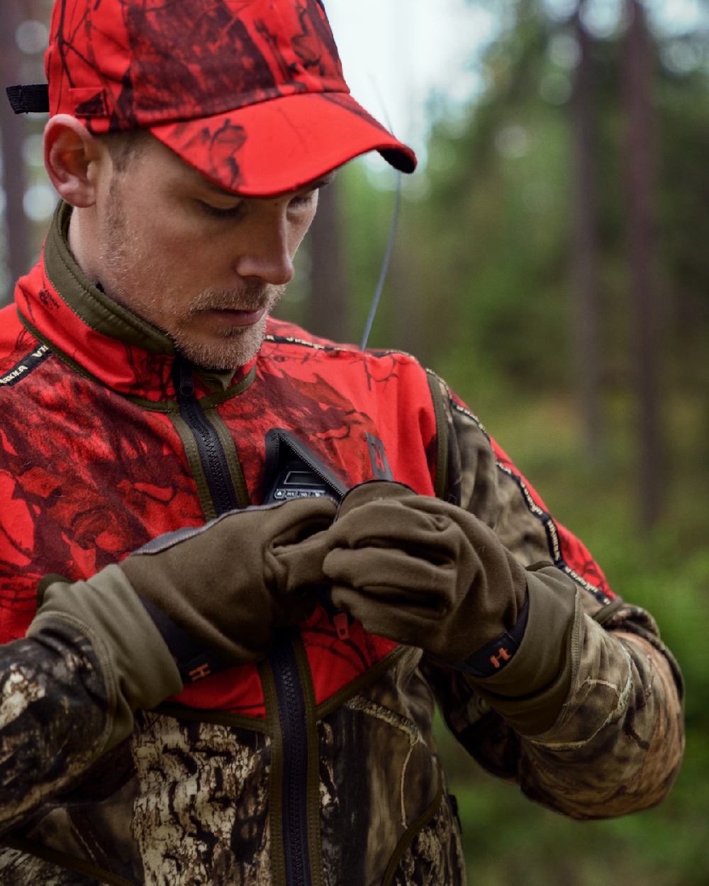 Hunting Green Mossy Oak Break-up Country Coloured Harkila Kamko Camo Reversible WSP Jacket on blurry background #colour_hunting-green-mossy-oak-break-up-country