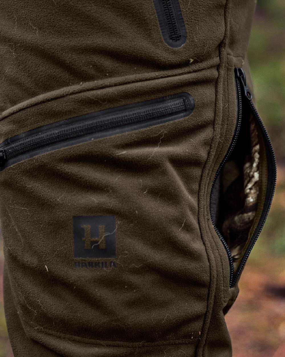 Hunting Green MossyOak Coloured Harkila Kamko Camo Reversible WSP Trousers on outdoor background #colour_hunting-green-mossyoak