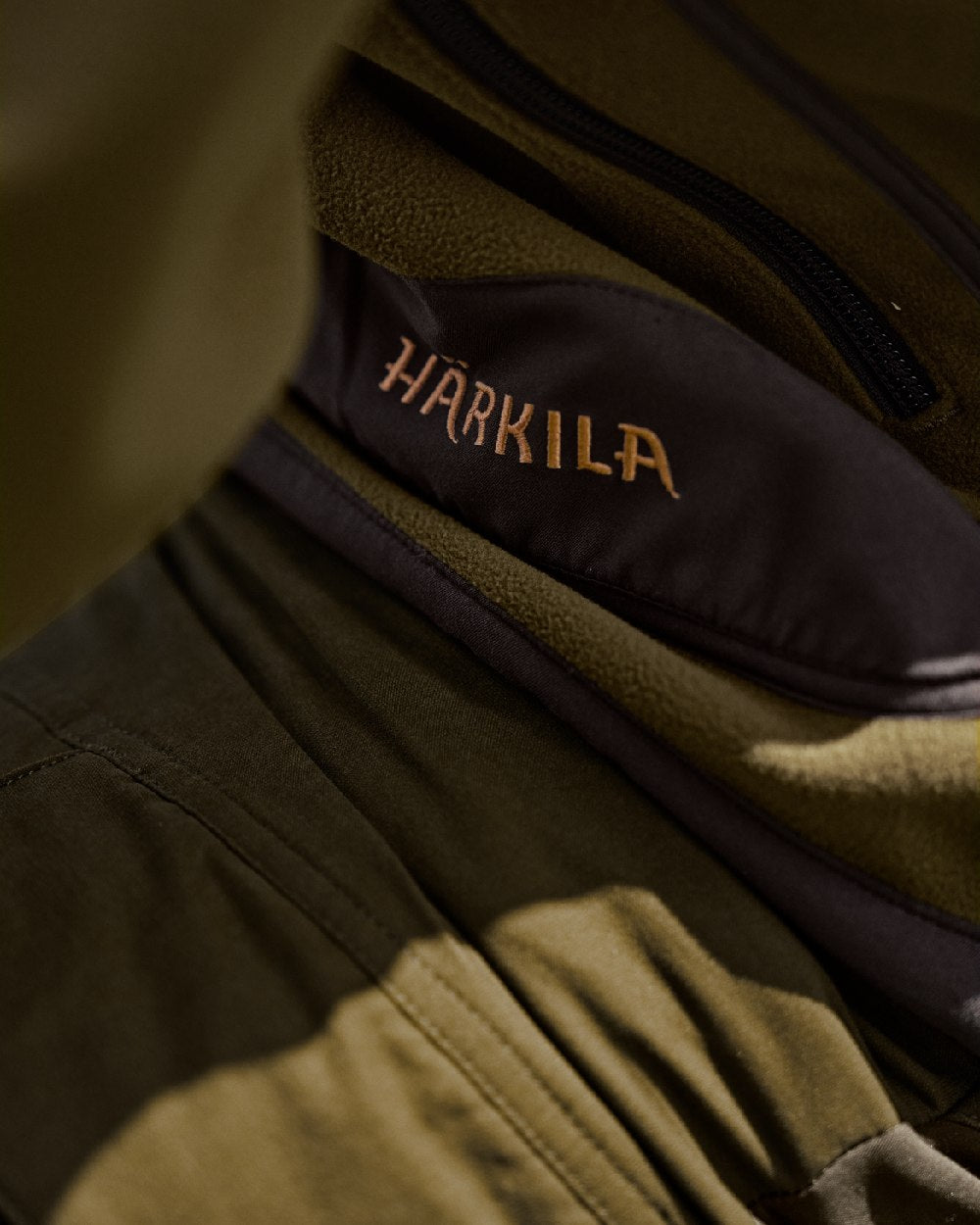 Dark Olive Arabian Spice Coloured Harkila Kamko Fleece on outdoor background #colour_dark-olive-arabian-spice