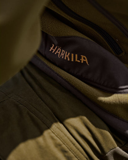 Dark Olive Arabian Spice Coloured Harkila Kamko Fleece on outdoor background #colour_dark-olive-arabian-spice