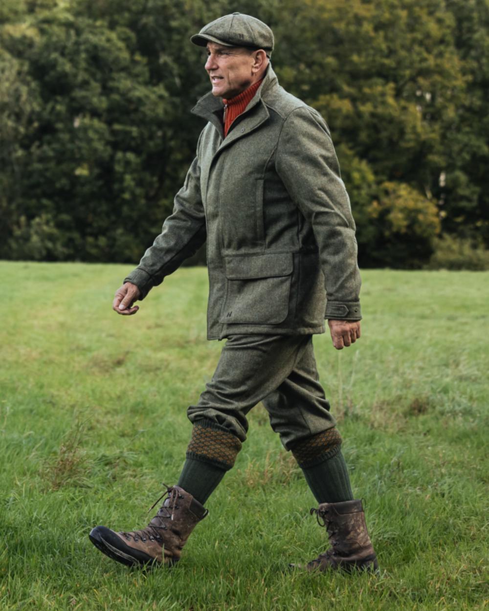 Forest Green Herringbone Coloured Harkila Kenmore GTX Jacket on forest background #colour_forest-green-herringbone