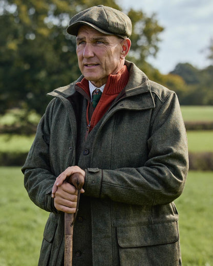 Forest Green Herringbone Coloured Harkila Kenmore GTX Jacket on forest background #colour_forest-green-herringbone