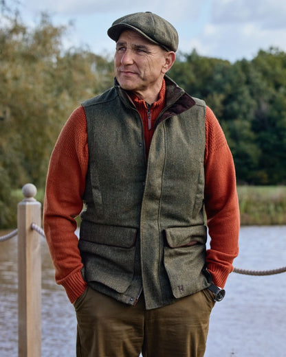 Forest Green Herringbone Coloured Harkila Kenmore Waistcoat on forest background #colour_forest-green-herringbone