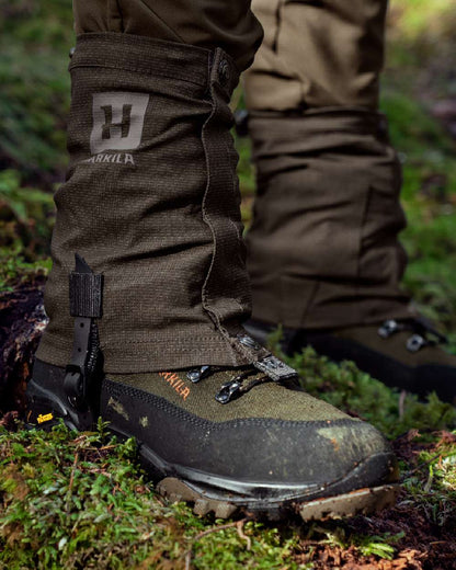 Shadow Brown Coloured Harkila Ledge Gaiters on forest background #colour_shadow-brown