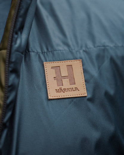 Willow Green Sea Blue Coloured Harkila Mens Kalix HSP Jacket on blurry background #colour_willow-green-sea-blue